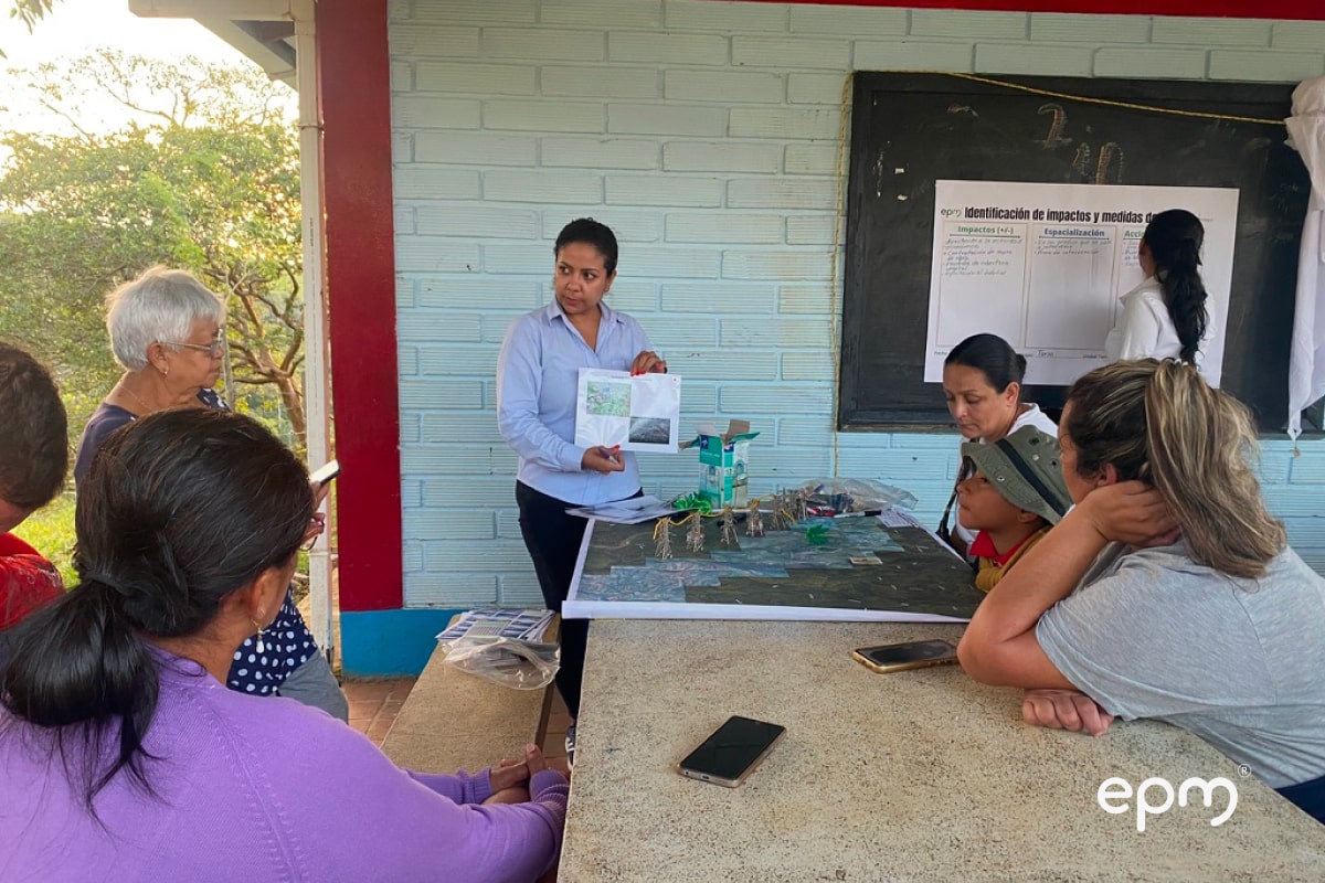 Fotografía de trabajadora de EPM conversando con los ciudadanos sobre el Proyecto Carrieles EPM