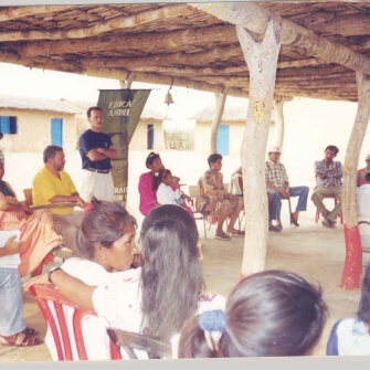 Comunidad reunida bajo techo de madera participando en un encuentro social y ambiental liderado por EPM en zona rural