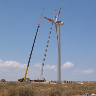 Grúas desmontando una pala de aerogenerador de gran altura en zona árida
