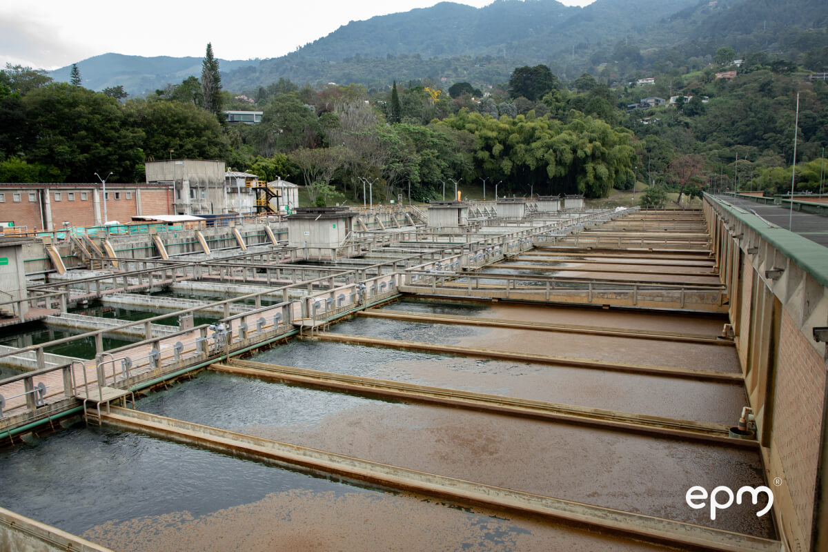 Estructuras hidráulicas y tanques de sedimentación de la planta La Ayurá, rodeadas de vegetación y montañas en Envigado.