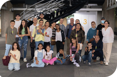 Grupo de niños, jóvenes y adultos posando para una foto durante una visita guiada en EPM, frente a una escalera interna.