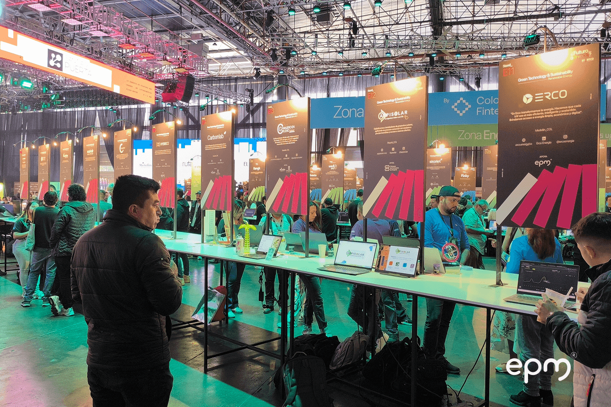 Fotografía de zona de exposición de startups en Startco 2025, con stands de emprendimientos tecnológicos alineados y visitantes interactuando.
