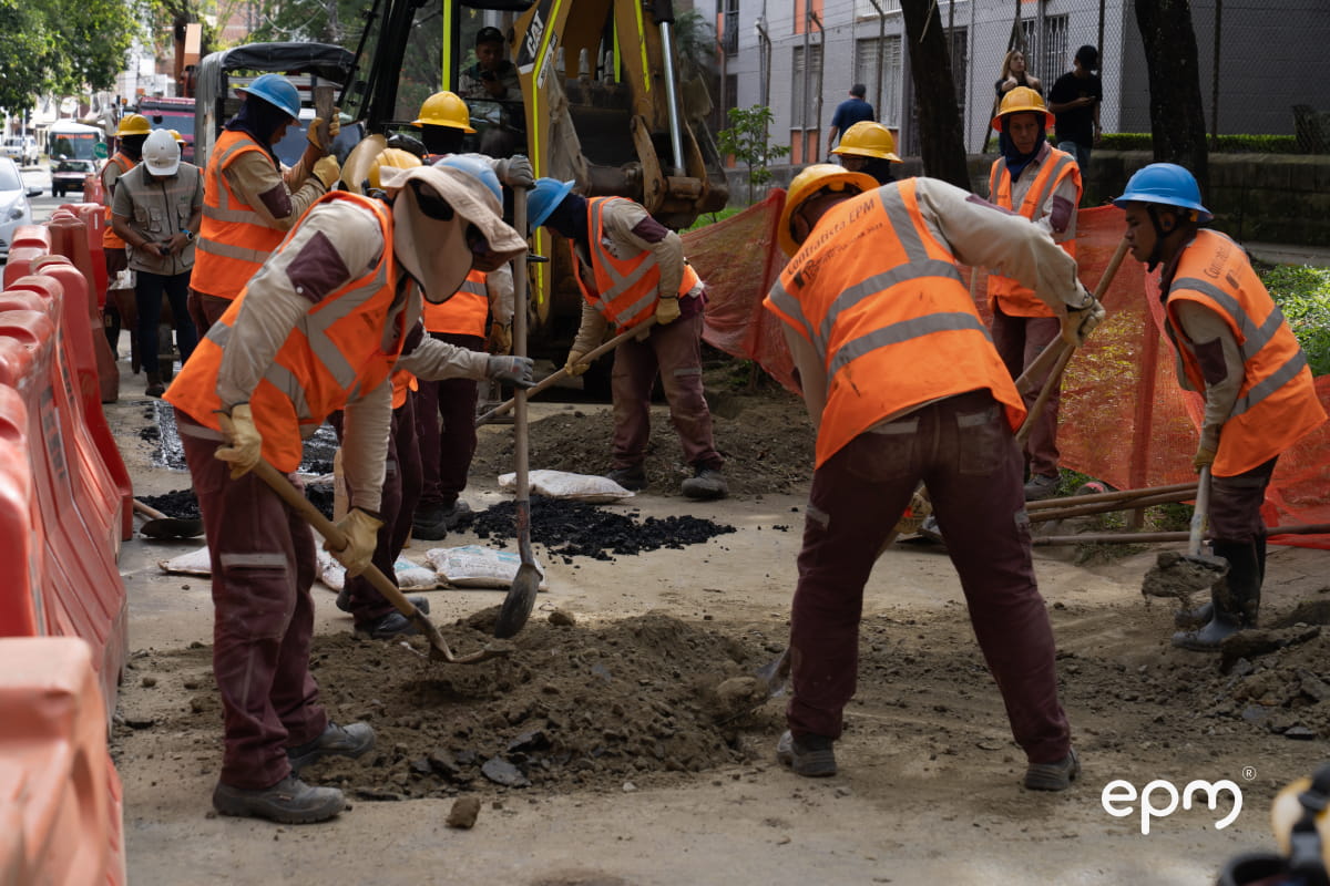 Funcionarios de EPM con chalecos naranjas realizando labores de mantenimiento en las calles del municipio de Bello