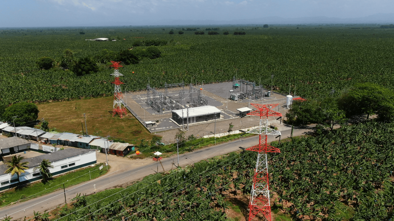 Vista aérea de una subestación eléctrica en medio de un vasto campo verde