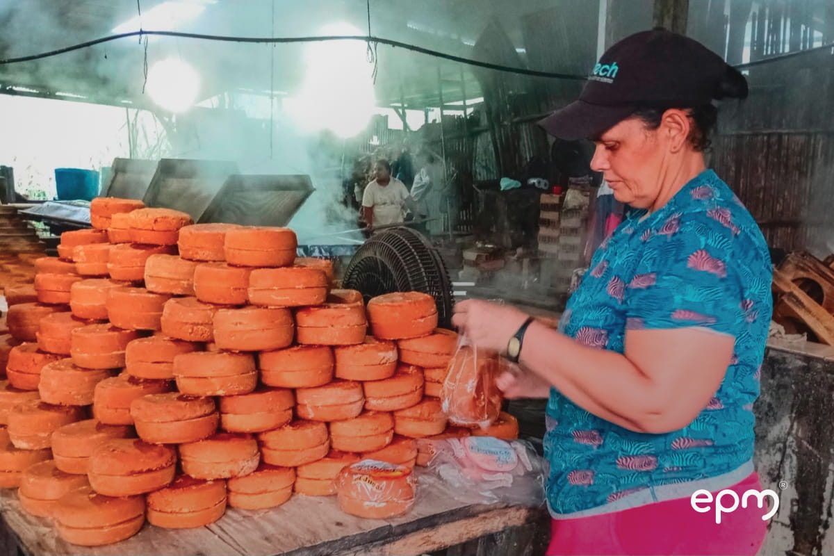 Una mujer empacando panelas de caña en una bolsa