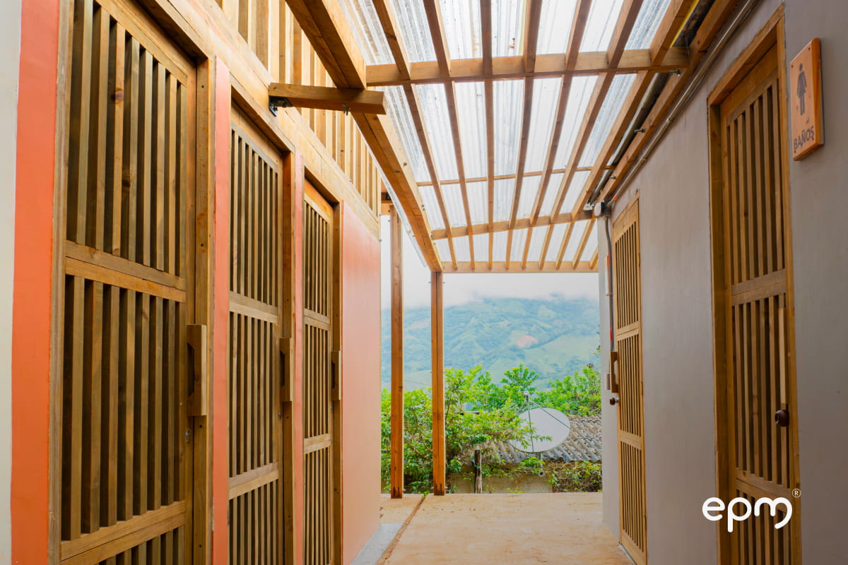 Fotografía de la escuela rural entregada por EPM y Amalfi donde se observan puertas en madera y paredes en color naranja