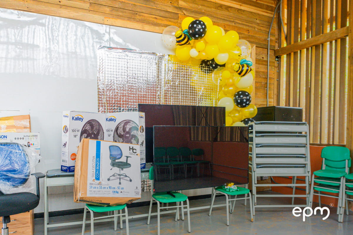 Aula de clase con sillas verdes, cortinas blancas y bombas amarillas