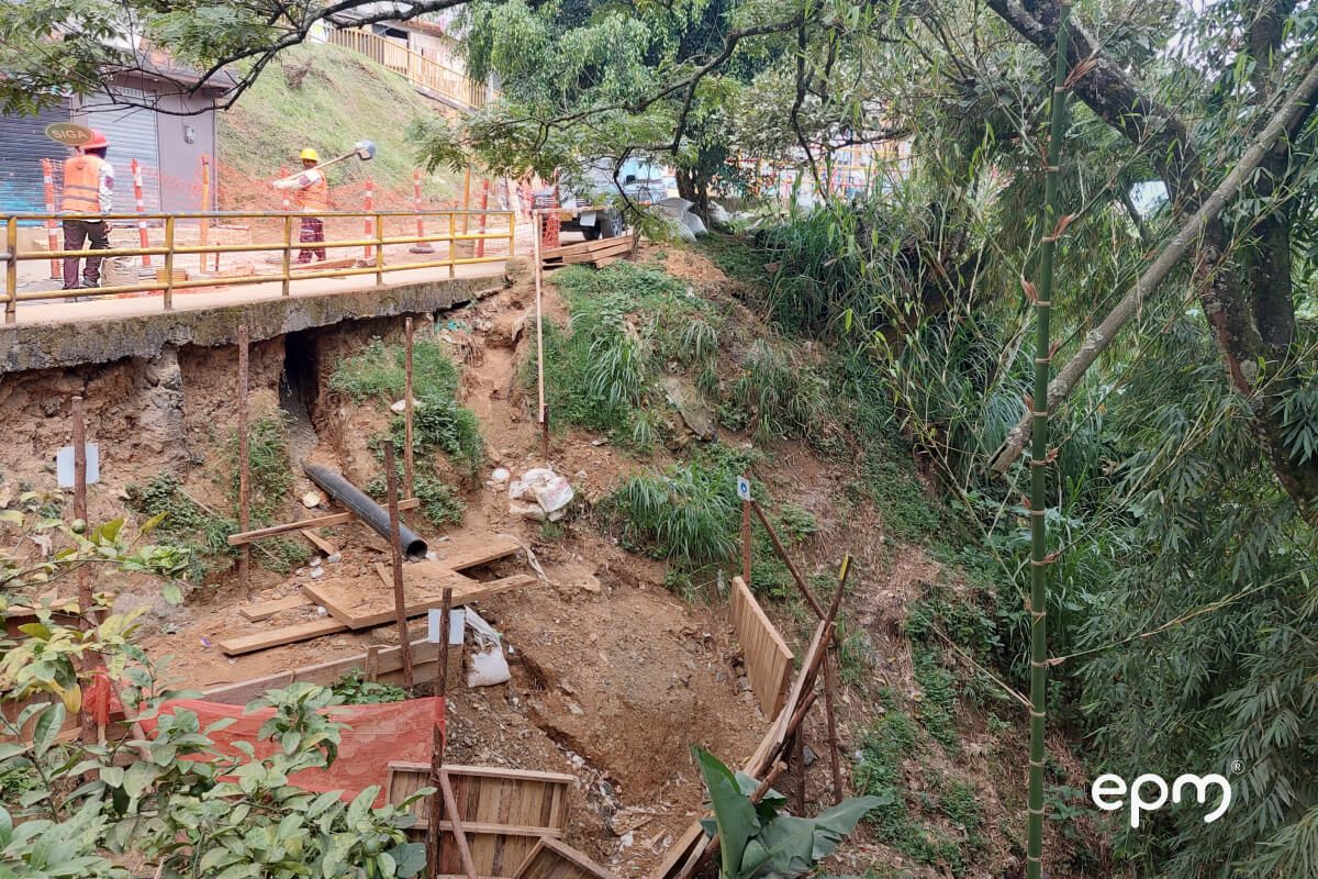 Fotografía de unos trabajadores de EPM en una zona de obra con excavaciones, tuberías y estructuras en construcción, mejorando el sistema de acueducto y alcantarillado.
