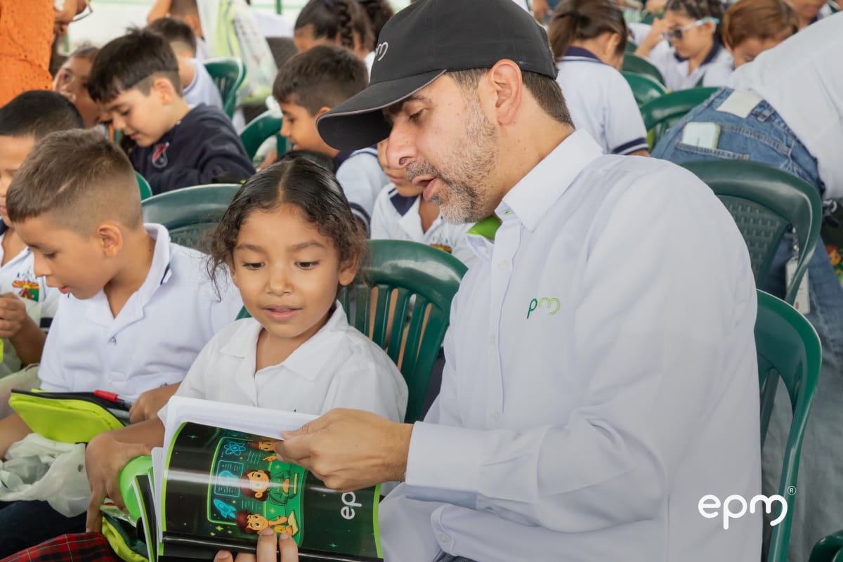 Persona de EPM compartiendo con niños durante entrega de kits escolares en el municipio de Liborina