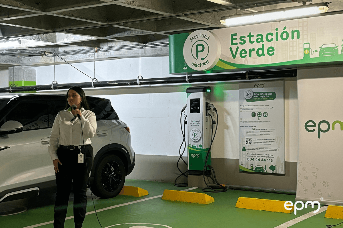 Fotografía de representante de EPM en la inauguración de estación verde para vehículos eléctricos en El Tesoro, junto a punto de carga y señalización.
