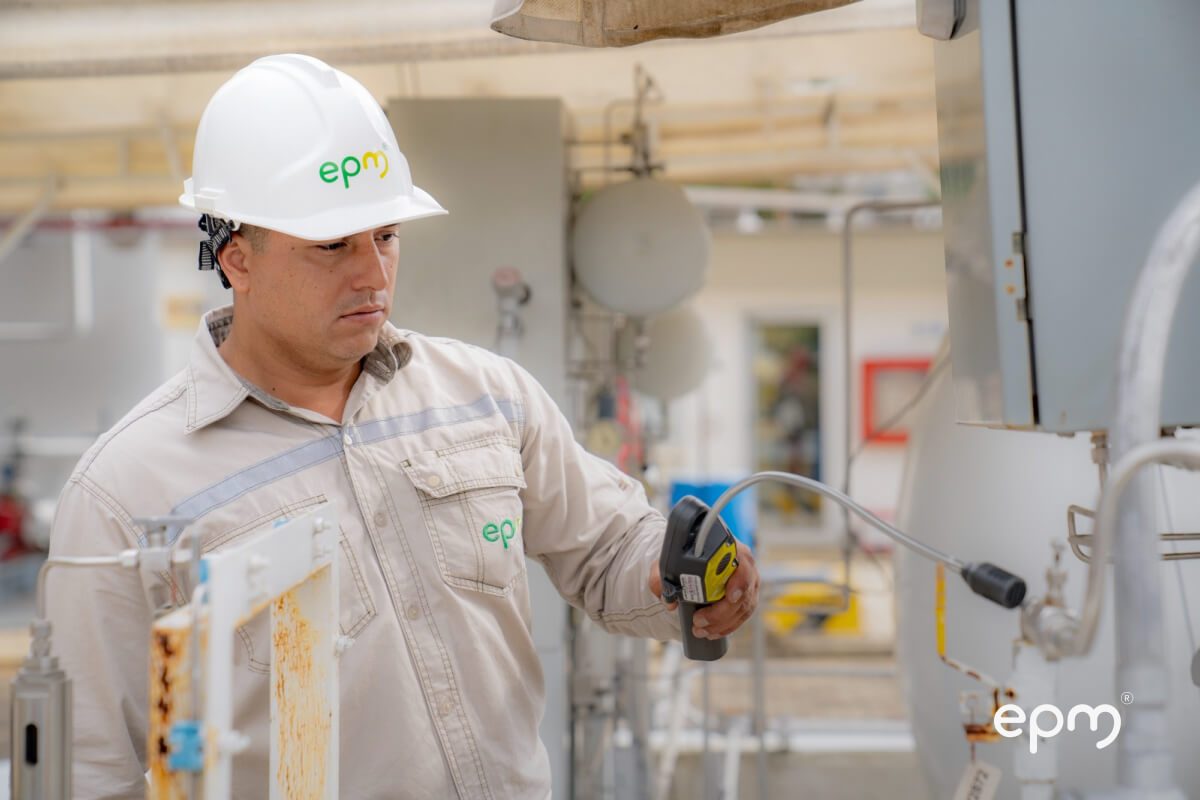 Fotografía de técnico de EPM con casco y uniforme inspeccionando un sistema de gas natural 