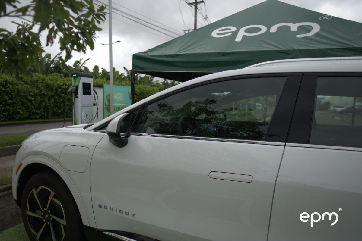 Vehículo eléctrico cargando en estación de EPM bajo carpa institucional en Urabá.