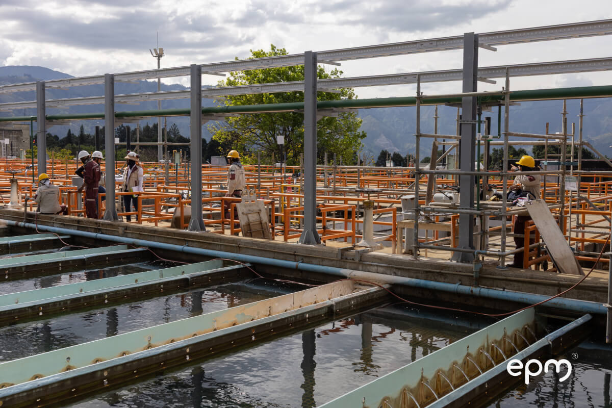 Obras de modernización en la planta de potabilización Manantiales, con presencia de trabajadores en estructuras y canales de agua.