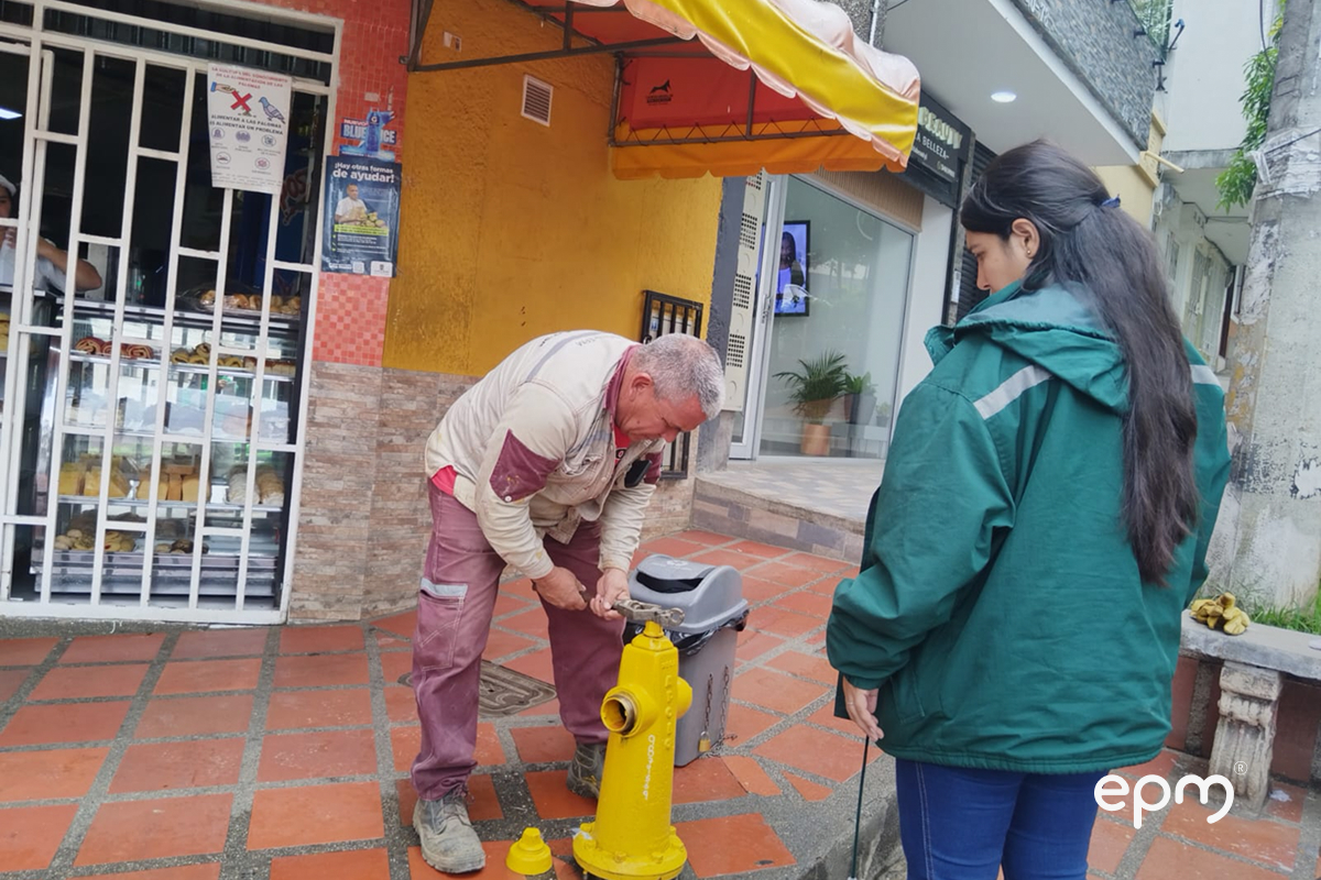Funcionario de EPM trabjando en hidrante de color amarillo para suministrar agua a la comunidad