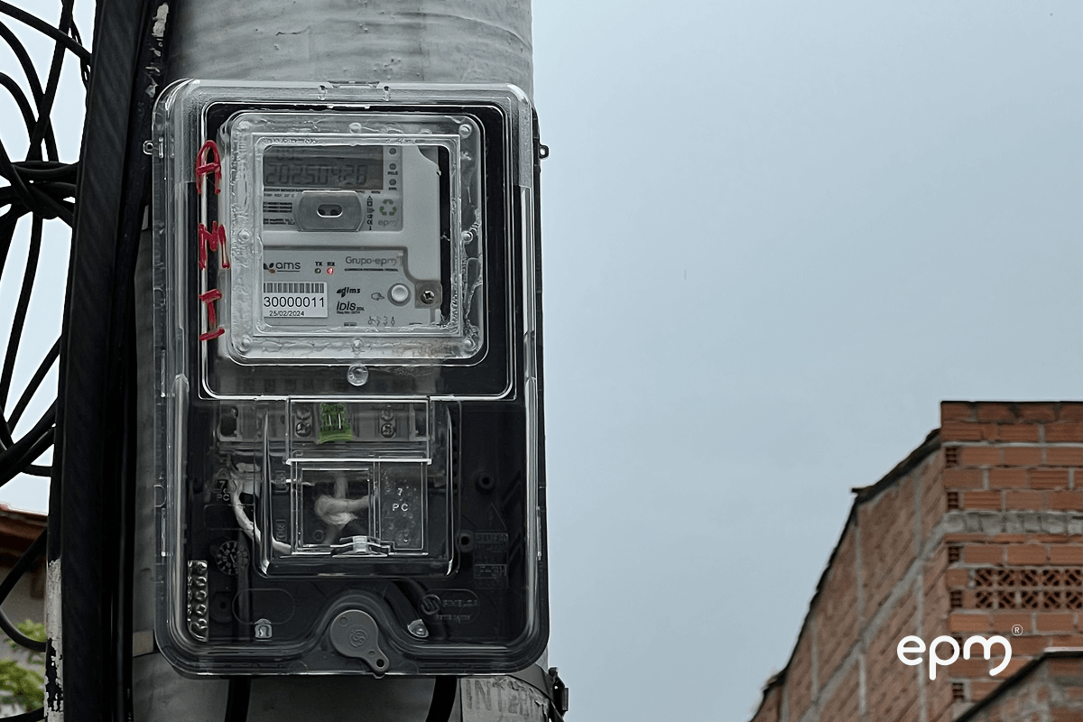 Fotografía de un medidor digital instalado en poste en zona residencial, parte del programa de EPM con materiales reciclados para economía circular.