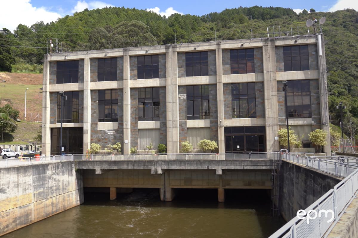 Fotografía de edificio de tres pisos con varias ventanas, ubicado sobre cuatro salidas de agua 