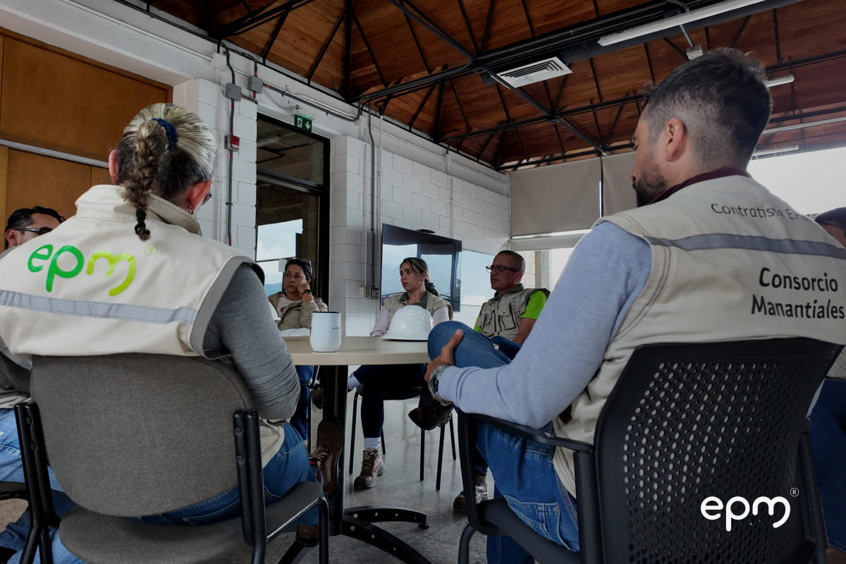 Equipo técnico de EPM y contratistas reunidos en mesa de trabajo revisando avances de la modernización de la planta Manantiales.