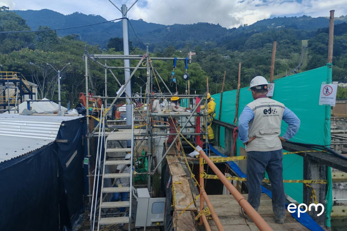 Personal de EPM con cascos y trajes de seguridad realiza trabajos de modernización en la planta La Ayurá, utilizando andamios y equipos de soporte