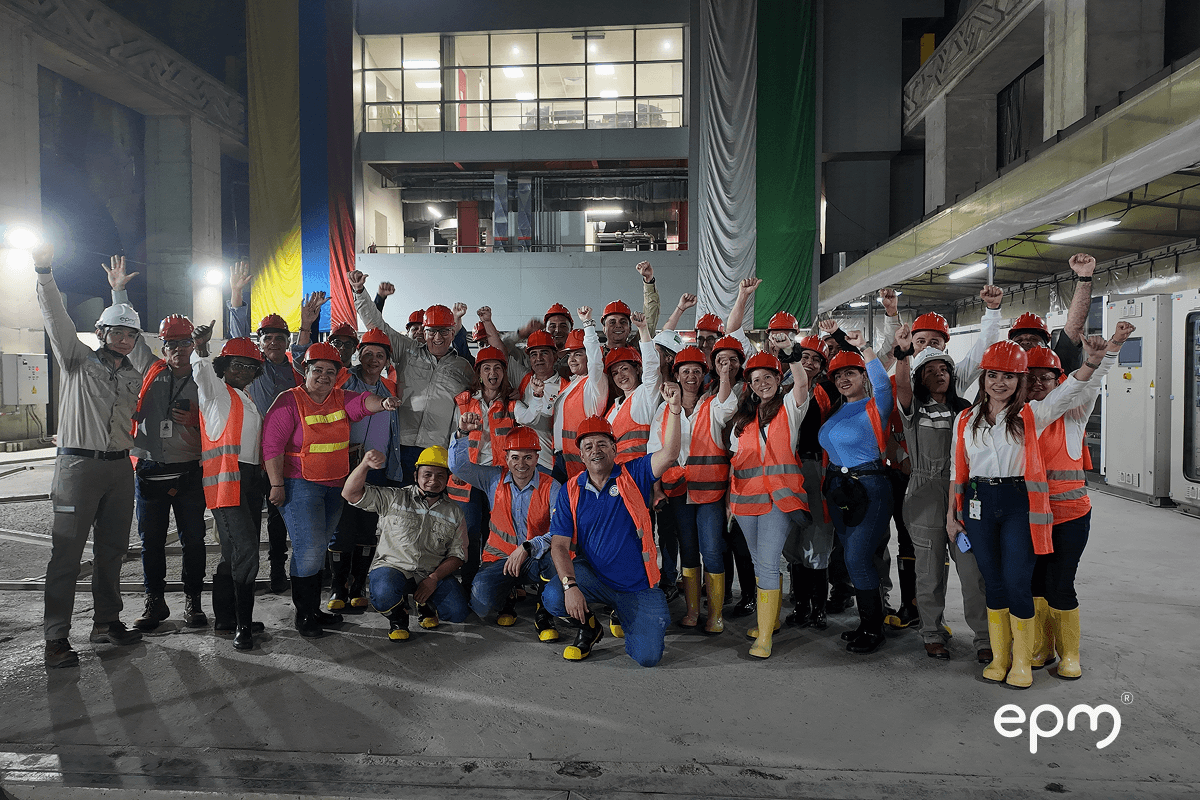 Imagen de un grupo de personas sonriendo y levantando sus manos 