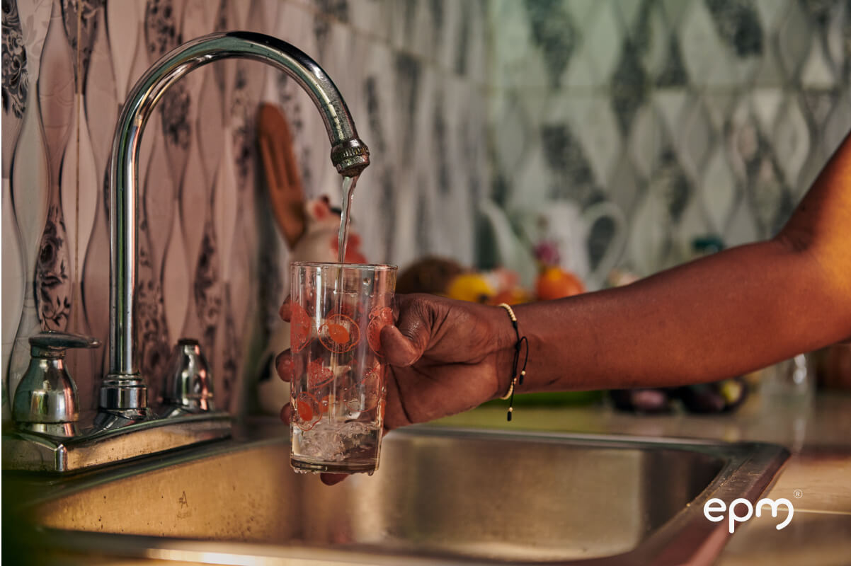 Persona sirviendo un vaso de agua