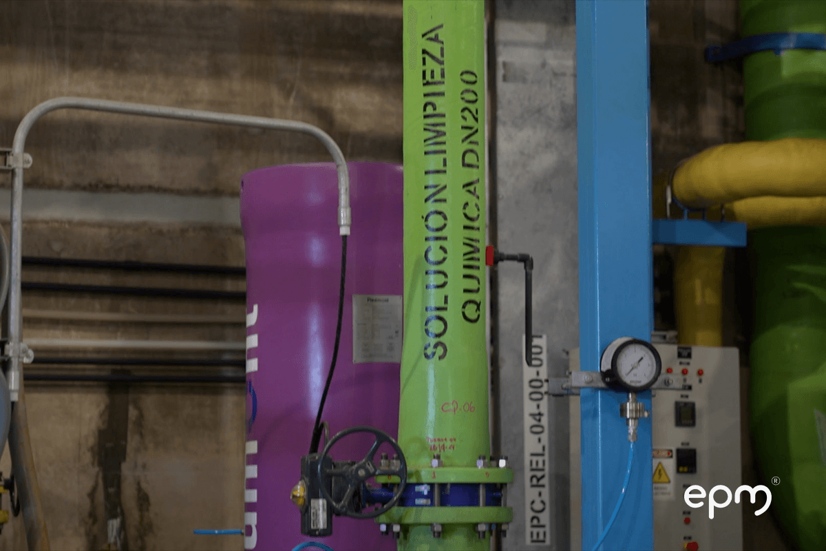 Fotografía detalle de las instalaciones internas de la planta de desalación, con tuberías de colores para soluciones químicas y sistemas de control.