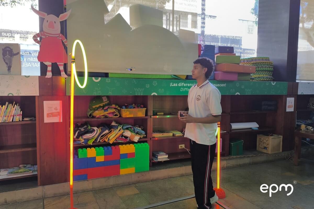 Fotografía de un Joven estudiante parado frente a un aro de luz