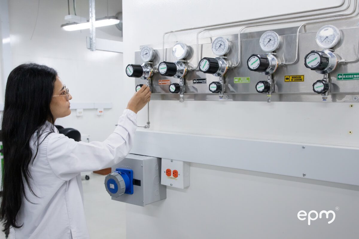 Fotografía de investigadora de EPM manipulando un sistema de control de gases en un laboratorio especializado.