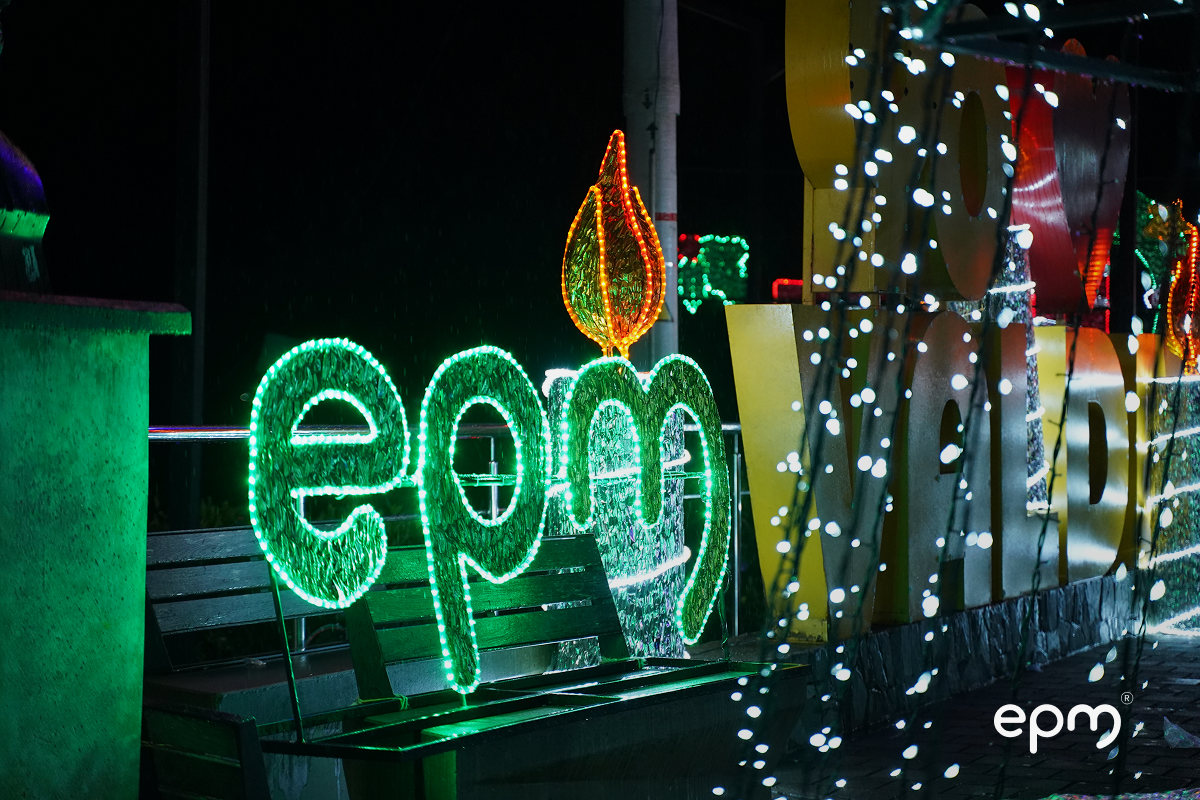 Alumbrado navideño con luces claras y en verde alumbra letrero de EPM en color verde