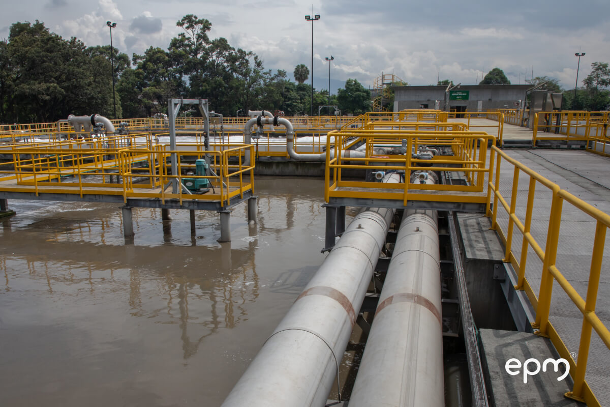 Planta de tratamiento de aguas residuales con tuberías y estructuras de seguridad en EPM.