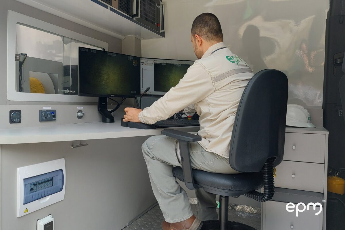 Fotografía de trabajador de EPM operando un sistema de monitoreo con doble pantalla en una estación móvil de inspección.