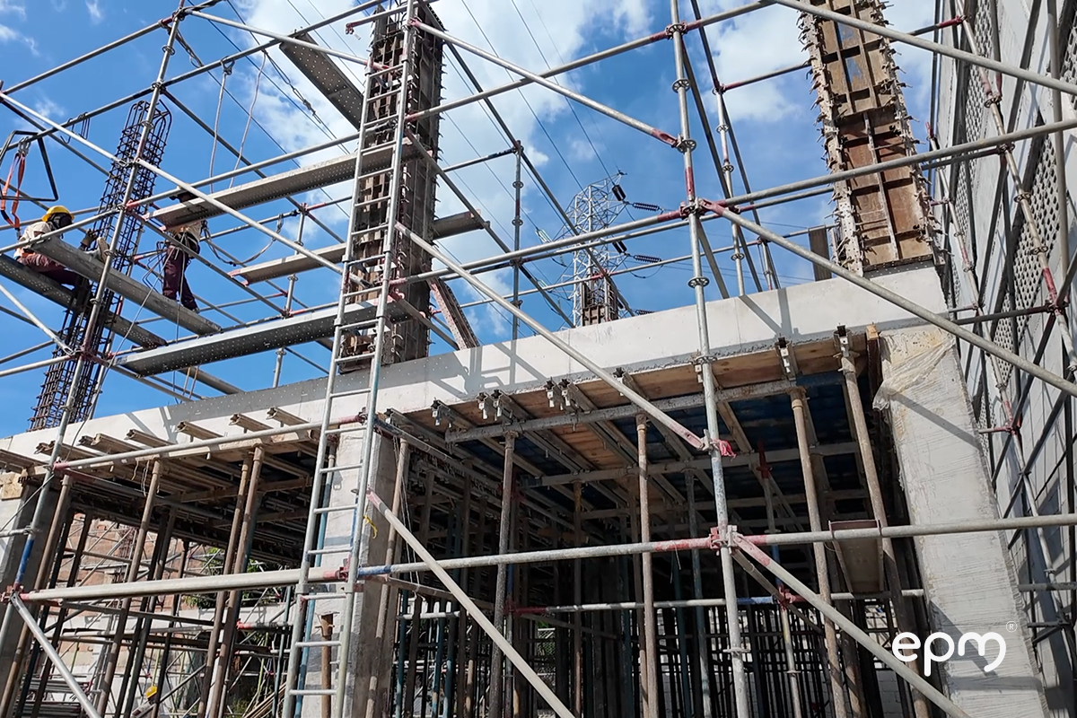 Funcionarios de EPM trabajando en subestación industrial. Se pueden observar andamios y estructuras en cemento y madera