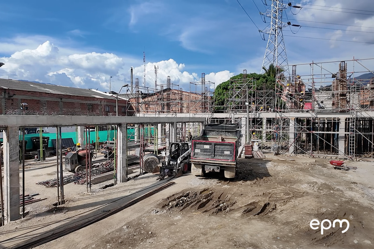Fotografía de la subestación industriales donde se observan funcionarios de EPM trabajando, carros parqueados y casas de fondo