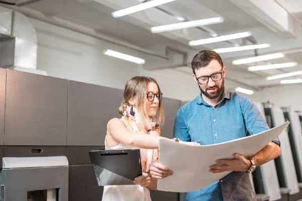 Dos personas mirando una publicación impresa