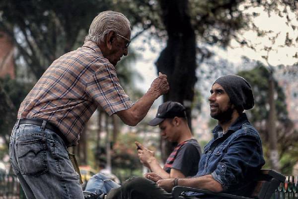 Tres personas conversando en un parque al aire libre
