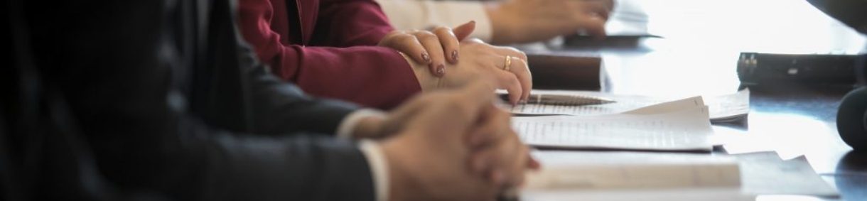 Imagen de un grupo de personas trabajando en un entorno profesional, con documentos y escritorios visibles