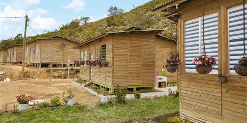 Casas de madera en un entorno natural, con jardines bien cuidados y macetas con flores colgadas en las fachadas.