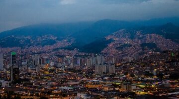 Vista panorámica de una ciudad con edificios modernos y un cielo parcialmente nublado, representando el concepto de ciudades inteligentes.