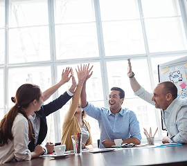 Ejecutivos reunidos chocando las manos como símbolo de alegría