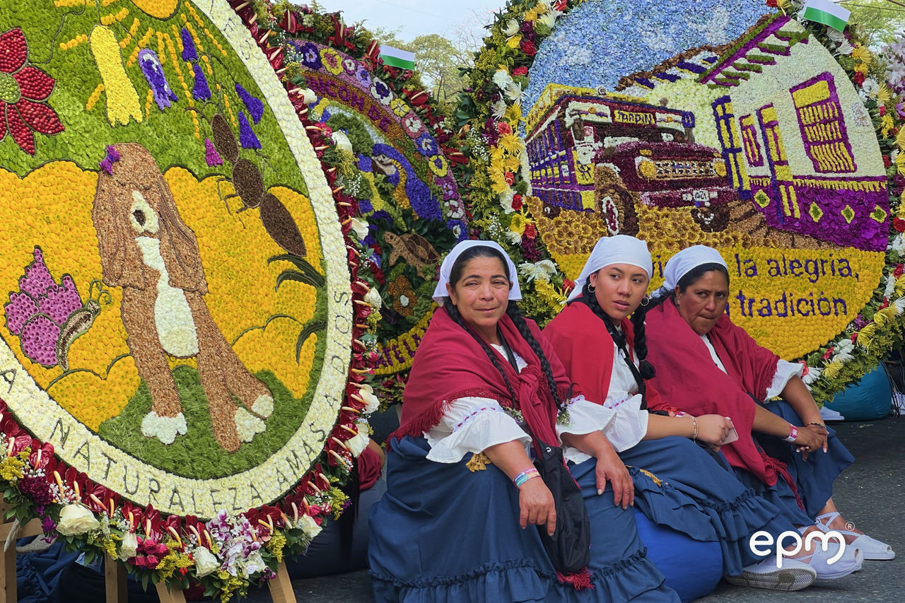 Silleteras posan junto a silletas elaboradas con flores durante el desfile