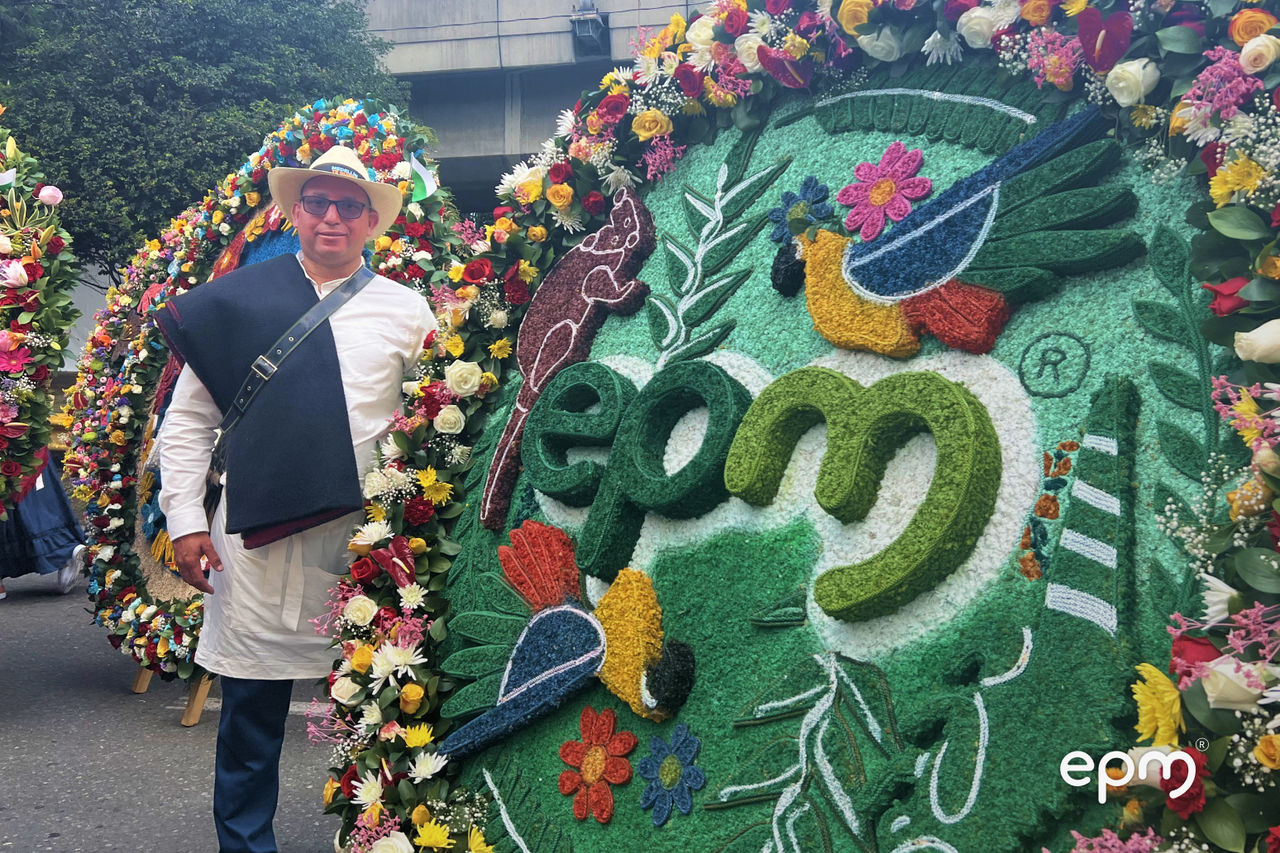 Participante posa junto a una silleta con elementos de biodiversidad y el logo de EPM