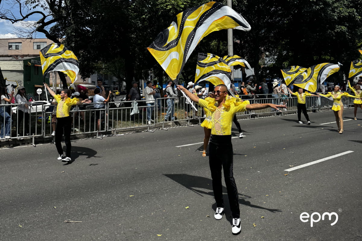 Integrantes de una comparsa realizan una presentación con banderas durante un desfile de la Feria