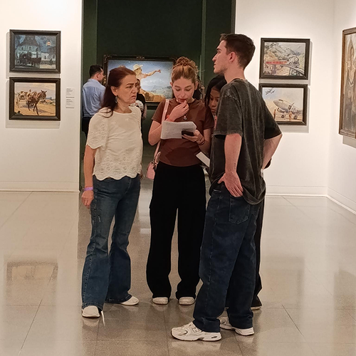 Visitantes observan y comentan obras durante un recorrido en una sala del Museo de Antioquia