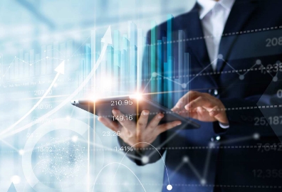 Persona de negocios usando una tablet mientras analiza gráficos financieros digitales con barras y flechas ascendentes