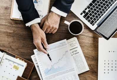 Manos sobre documentos financieros en un escritorio