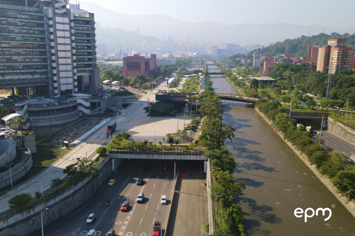 Vista aérea del río Medellín con vías vehiculares, zonas verdes y edificios urbanos a ambos lados del cauce