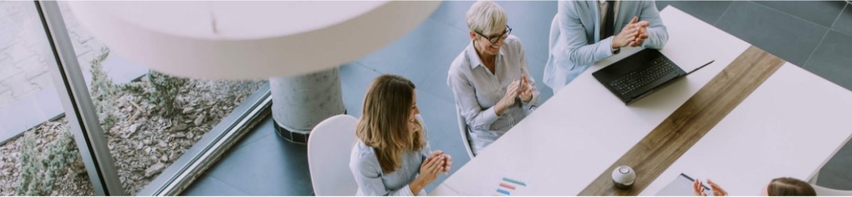 Frequently asked questions investors. Access to this content has an image of several people in a work environment talking at a table, one of them has a computer