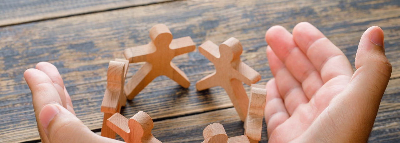 Wooden human figures holding hands
