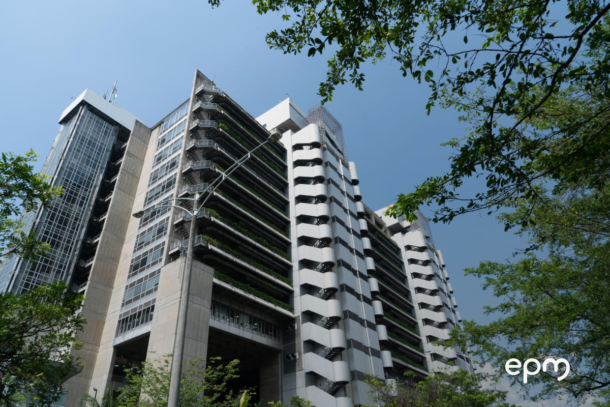 Fotografía del edificio de EPM donde se observan árboles y el cielo de fondo