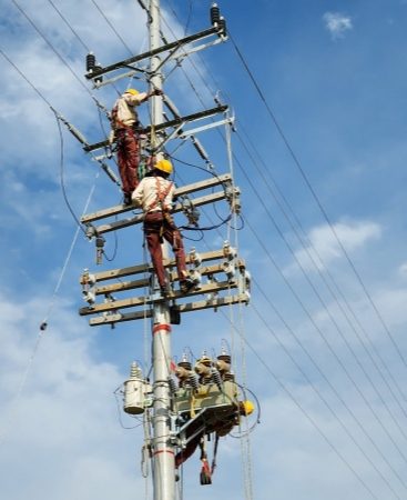 Trabajdores de EPM haciendo arreglos en un poste de energía