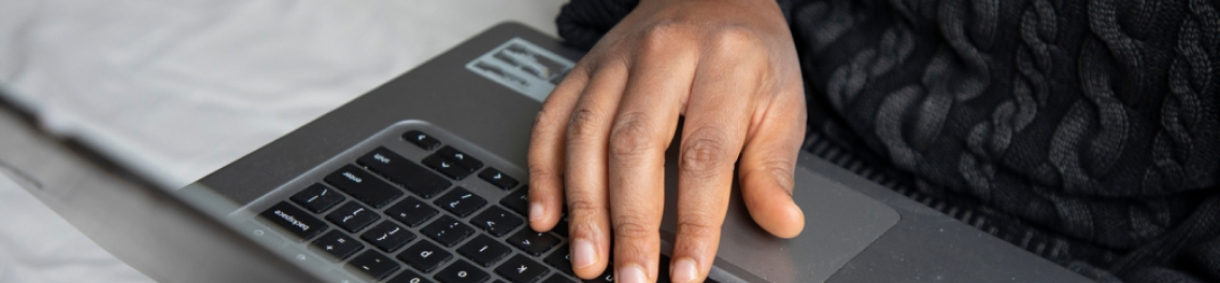 Mano sobre el teclado de un computador portátil